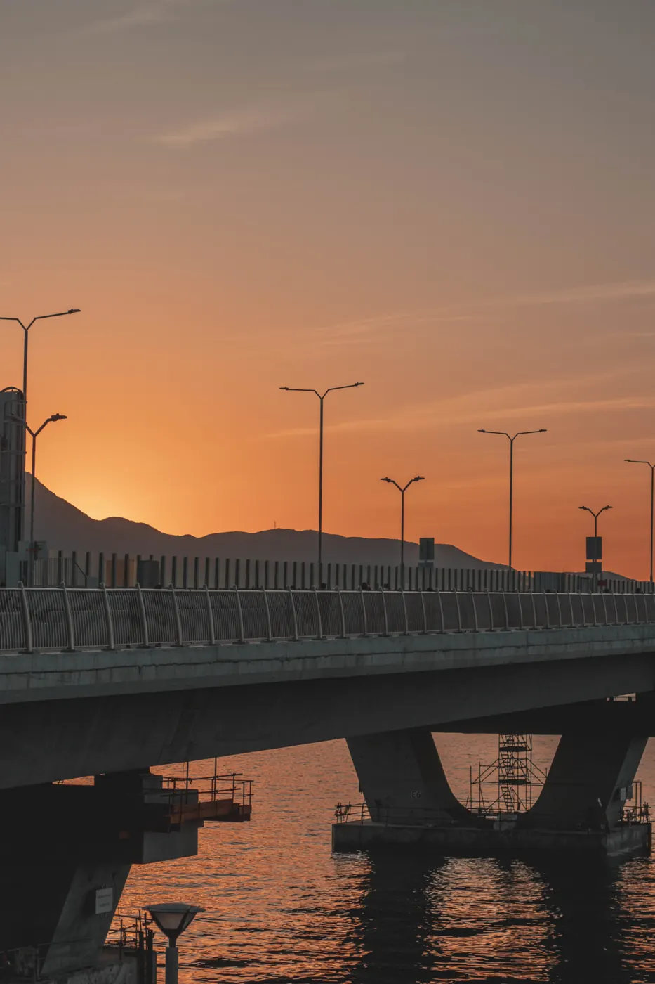 A Hong Kong road bridge over water at sunset