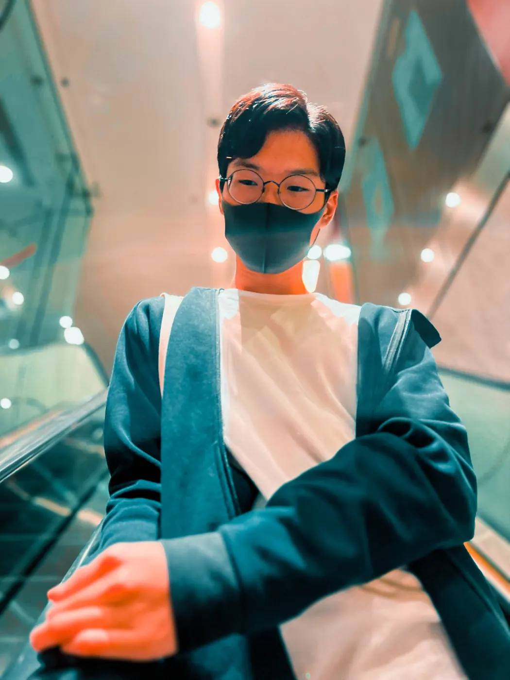 Acesley Chan standing on an escalator in Hong Kong