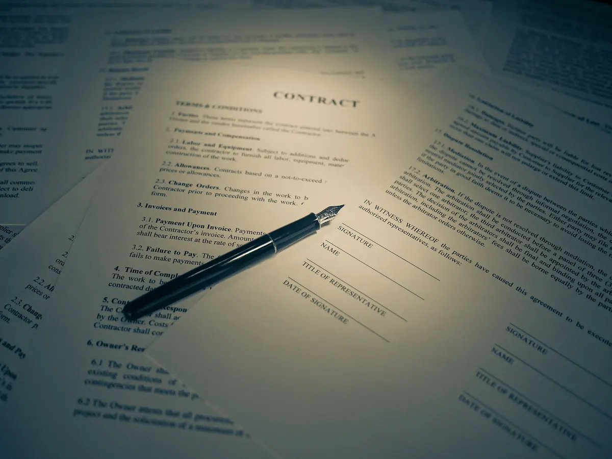 A pen resting on a printed contract